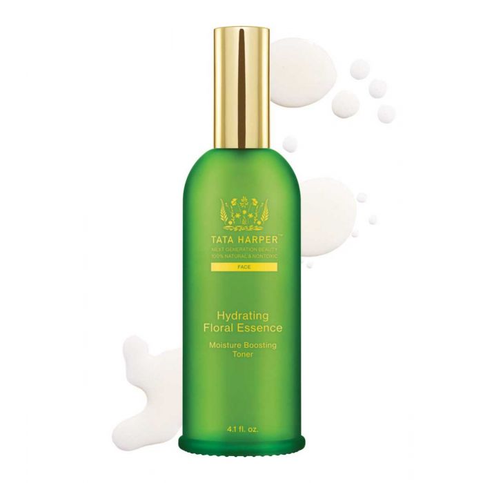 Green bottle of tata harper hydrating floral essence facial toner with product droplets around it.