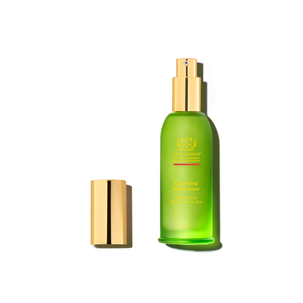Green bottle of tata harper clarifying moisturizer with gold cap, isolated on white background.