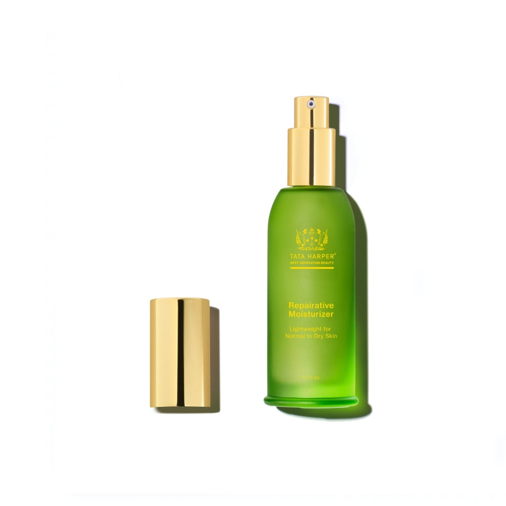 A green bottle of tata harper reparative moisturizer with a gold cap, isolated on a white background.