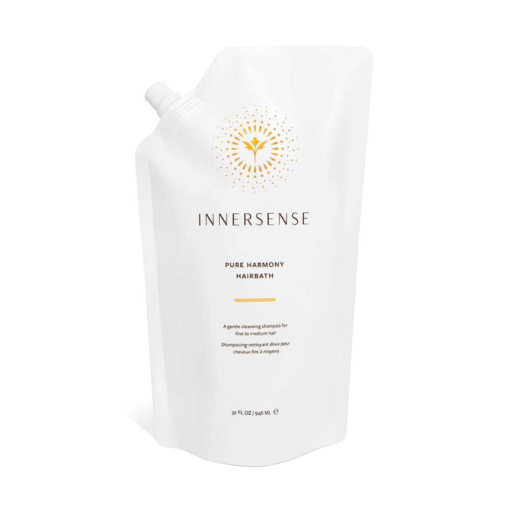 A white pouch of innersense pure harmony hairbath shampoo with a simple design and a sunburst logo.