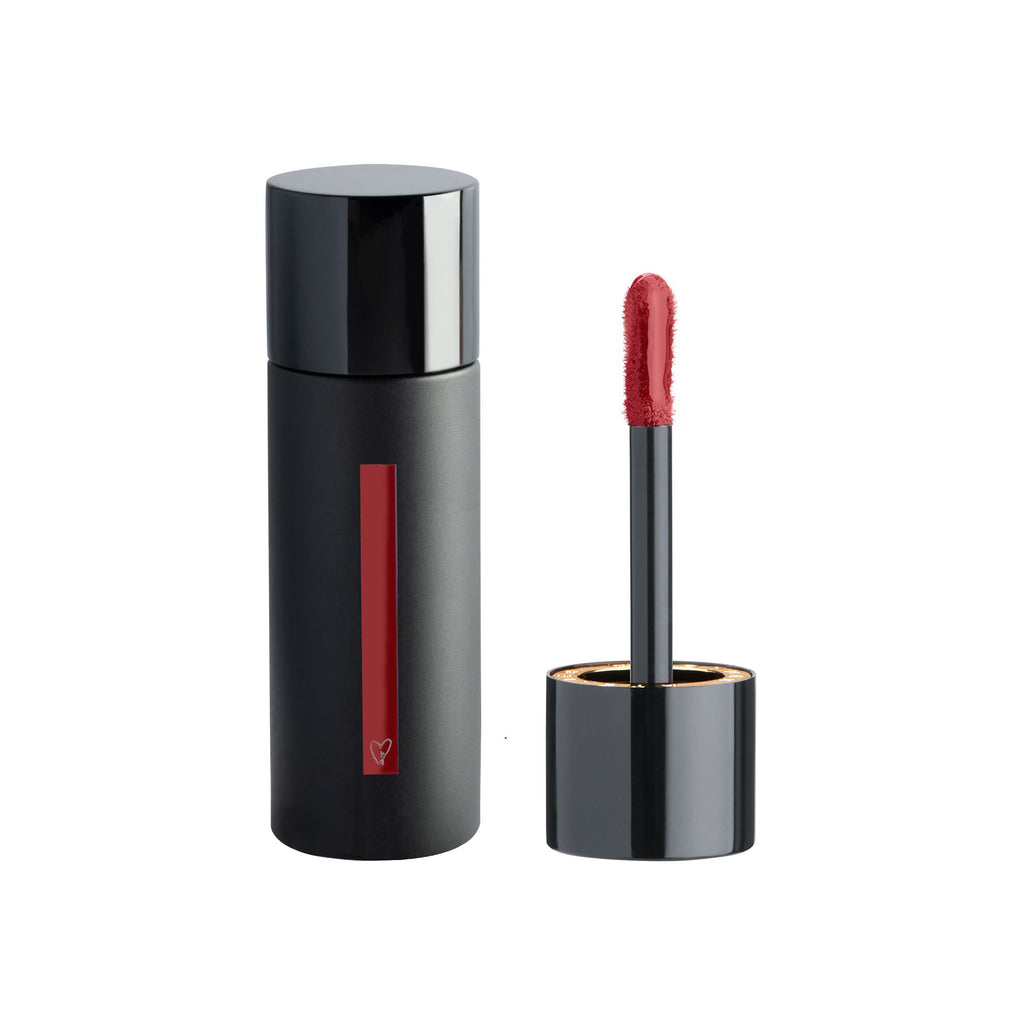 Lipstick with applicator beside its container.