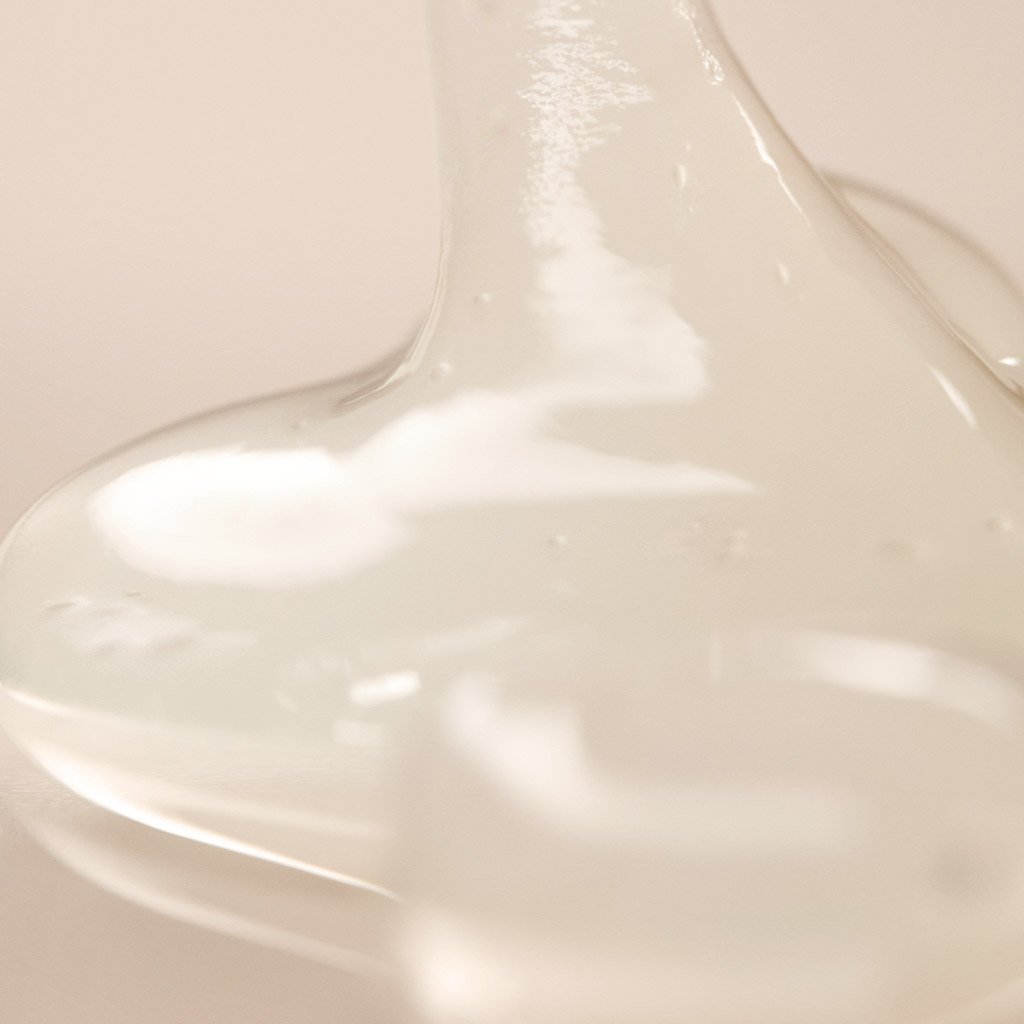 Close-up of a transparent viscous substance flowing down a smooth surface.