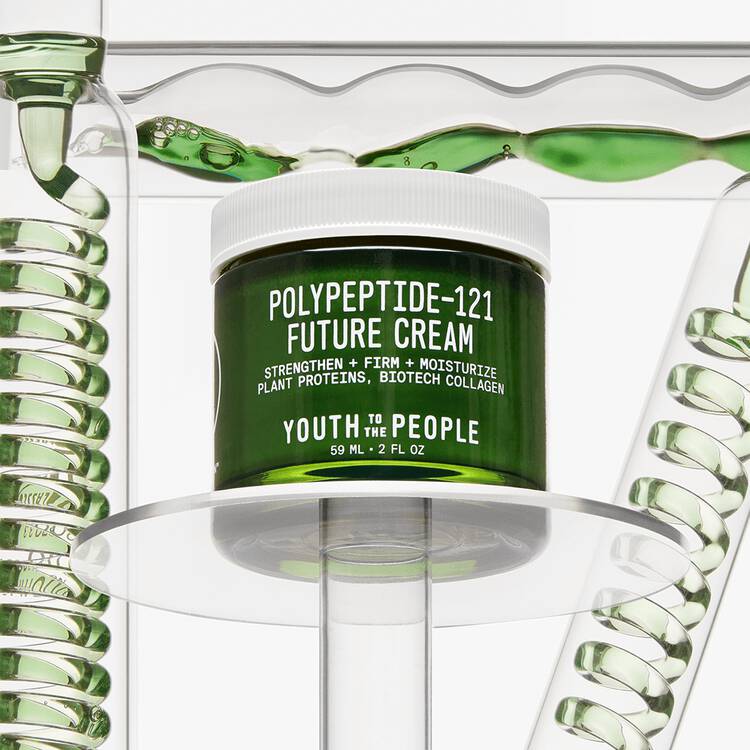 Jar of "youth to the people" polypeptide-121 future cream on a clear display stand with a fluid green backdrop.