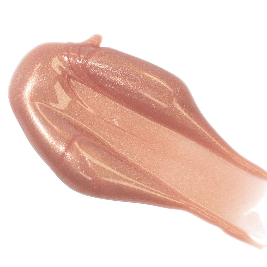 A swatch of shimmery rose-gold liquid lipstick or gloss smeared on a surface.