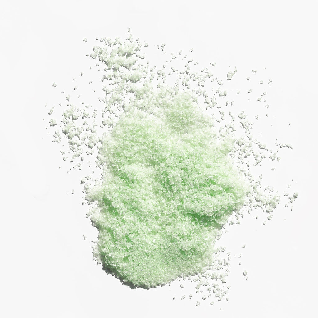 Scattered green powder on a white background.