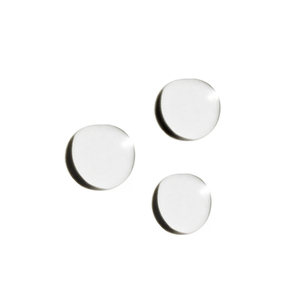 Three round white pills on a white background.