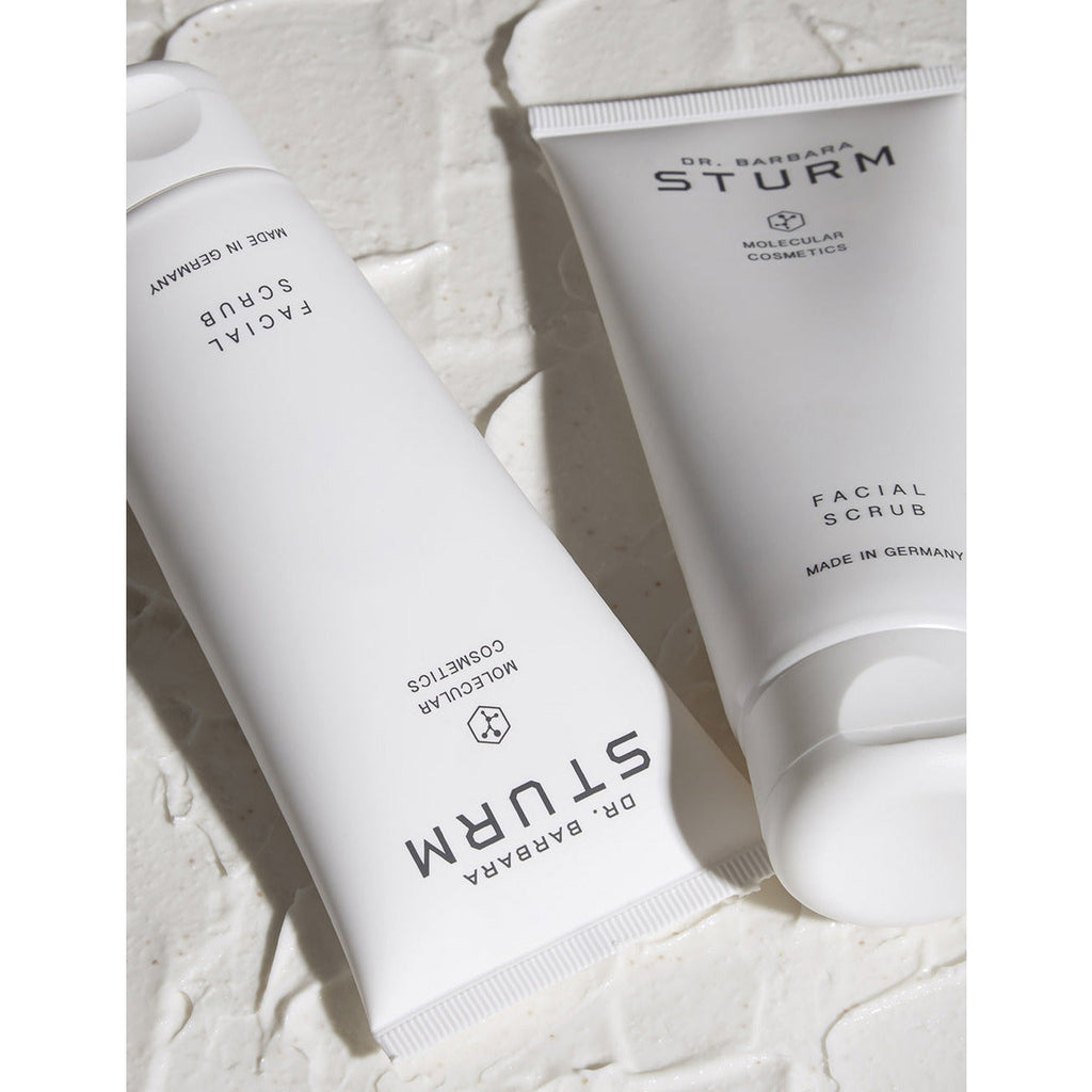 Two skincare product tubes lying on a textured surface.