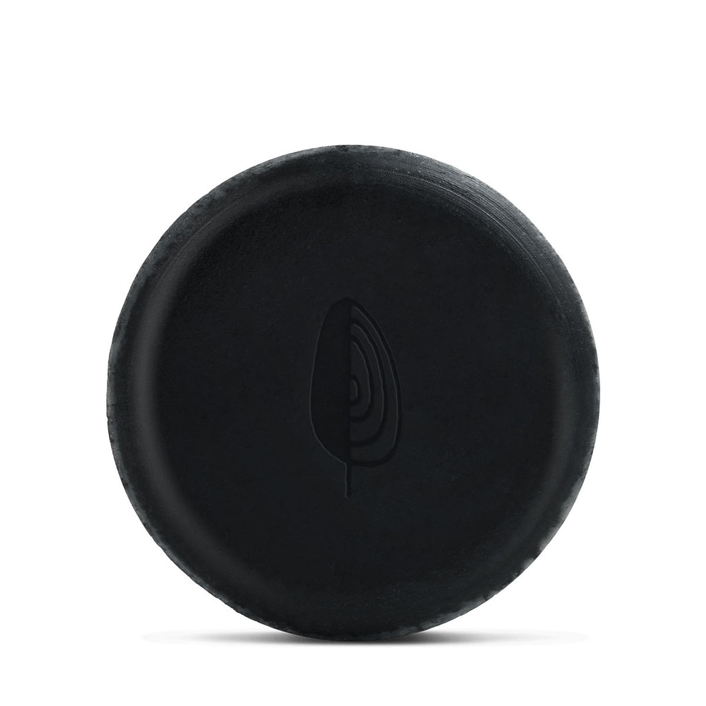Black hockey puck against a white background.