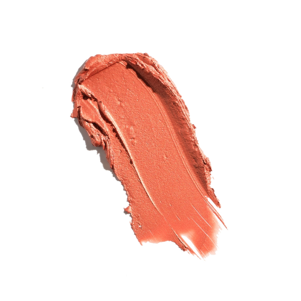 Smear of coral lipstick on a white background.