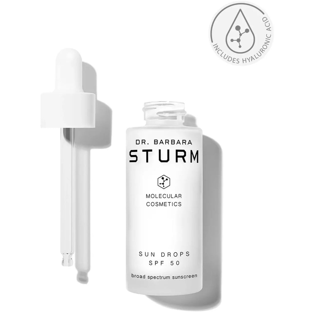 Bottle of dr. barbara sturm sun drops spf 50 sunscreen with a dropper applicator, highlighting the inclusion of hyaluronic acid in the formula.