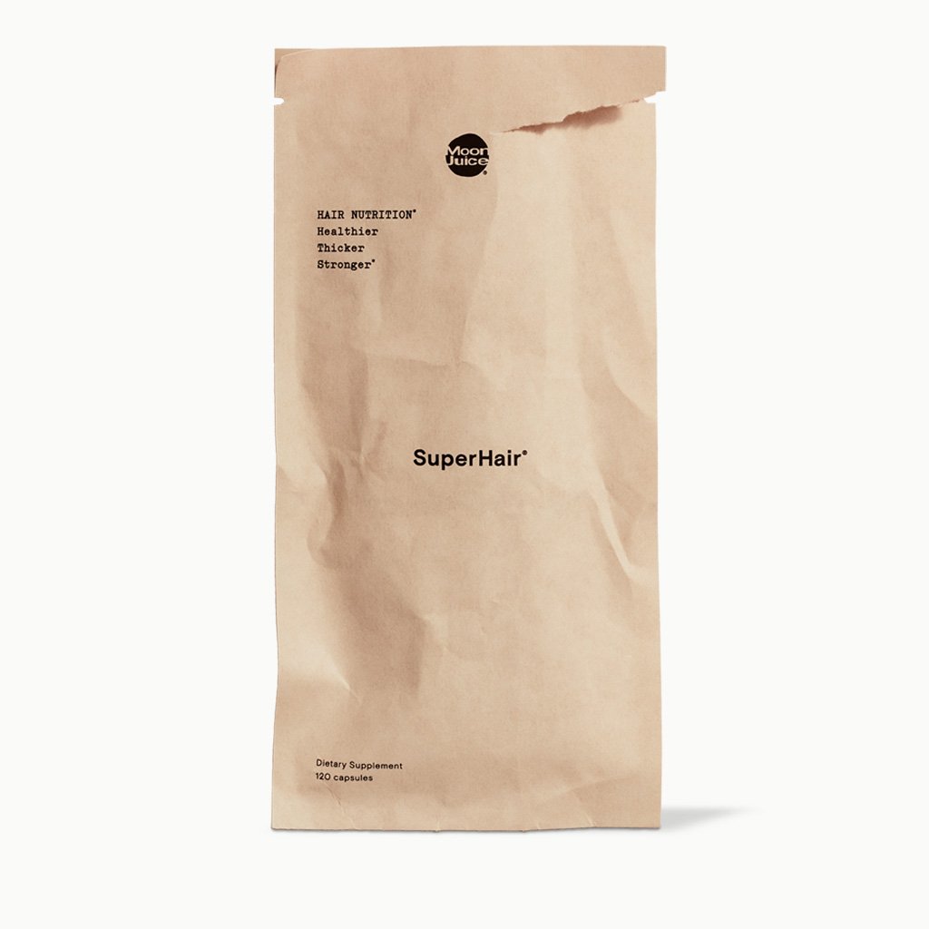 A crumpled brown paper bag labeled "superhair" dietary supplements by moon juice.
