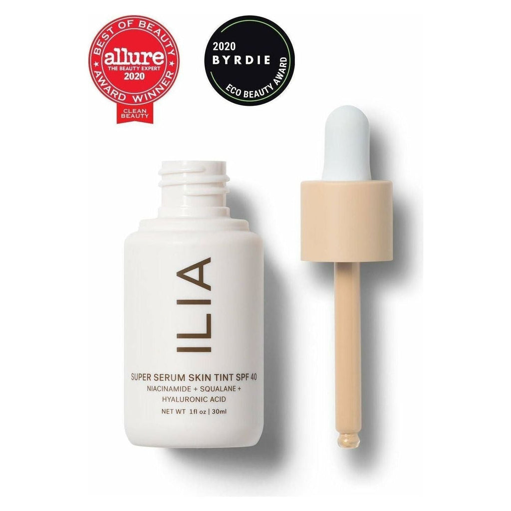 A bottle of ilia super serum skin tint spf 40 with a dropper, displaying beauty award badges from allure and byrdie.
