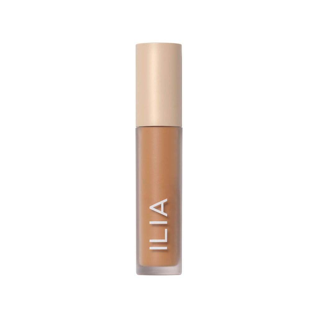 A bottle of ilia brand liquid foundation with a beige cap.
