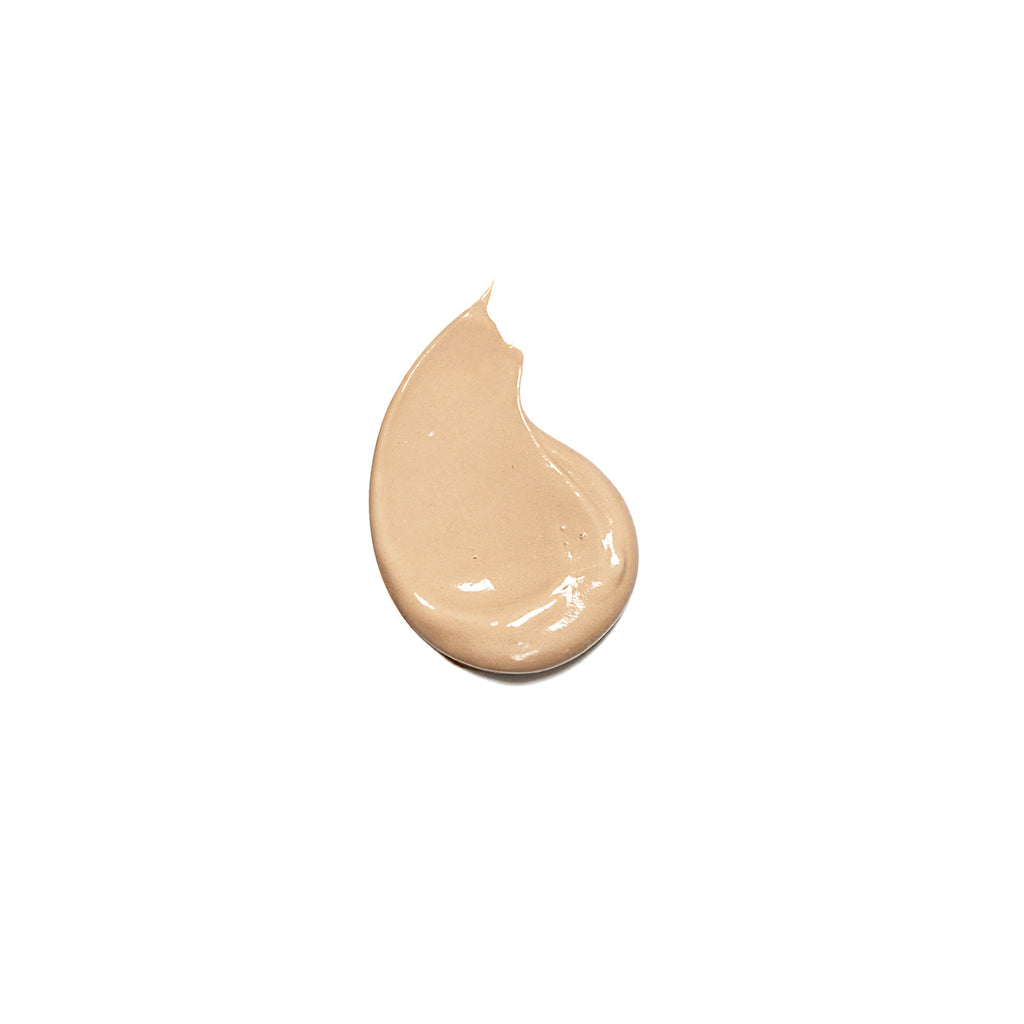 A dollop of liquid foundation makeup on a plain background.