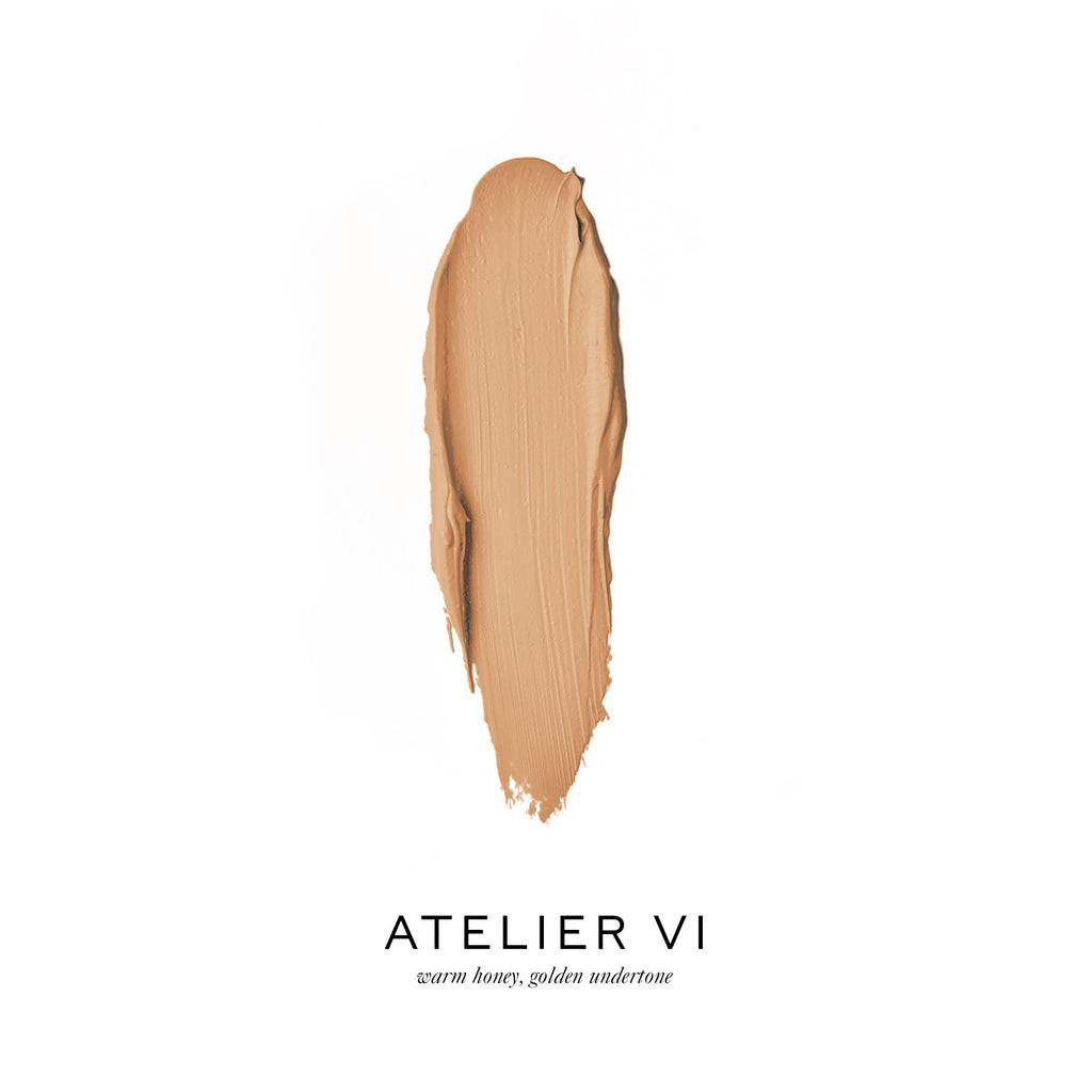 Smear of warm honey-toned foundation makeup with the label "atelier vi.