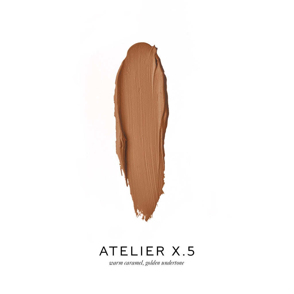 Smudge of warm caramel foundation with a golden undertone on a white background.