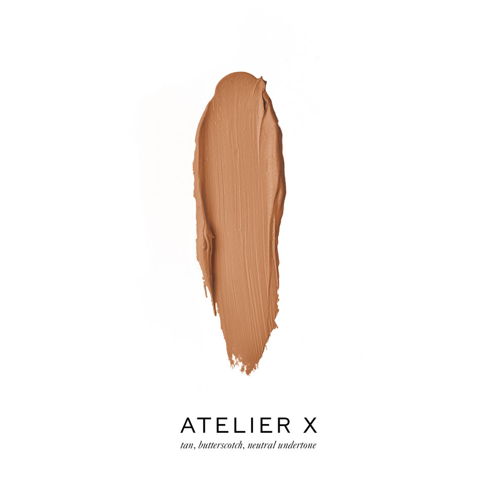 A swatch of tan foundation makeup with a butterscotch, neutral undertone, labeled "atelier x".