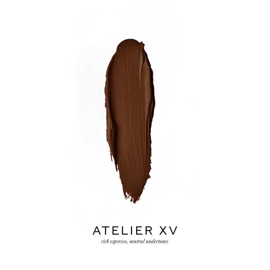 A swatch of rich espresso-colored makeup foundation with the label "atelier xv.
