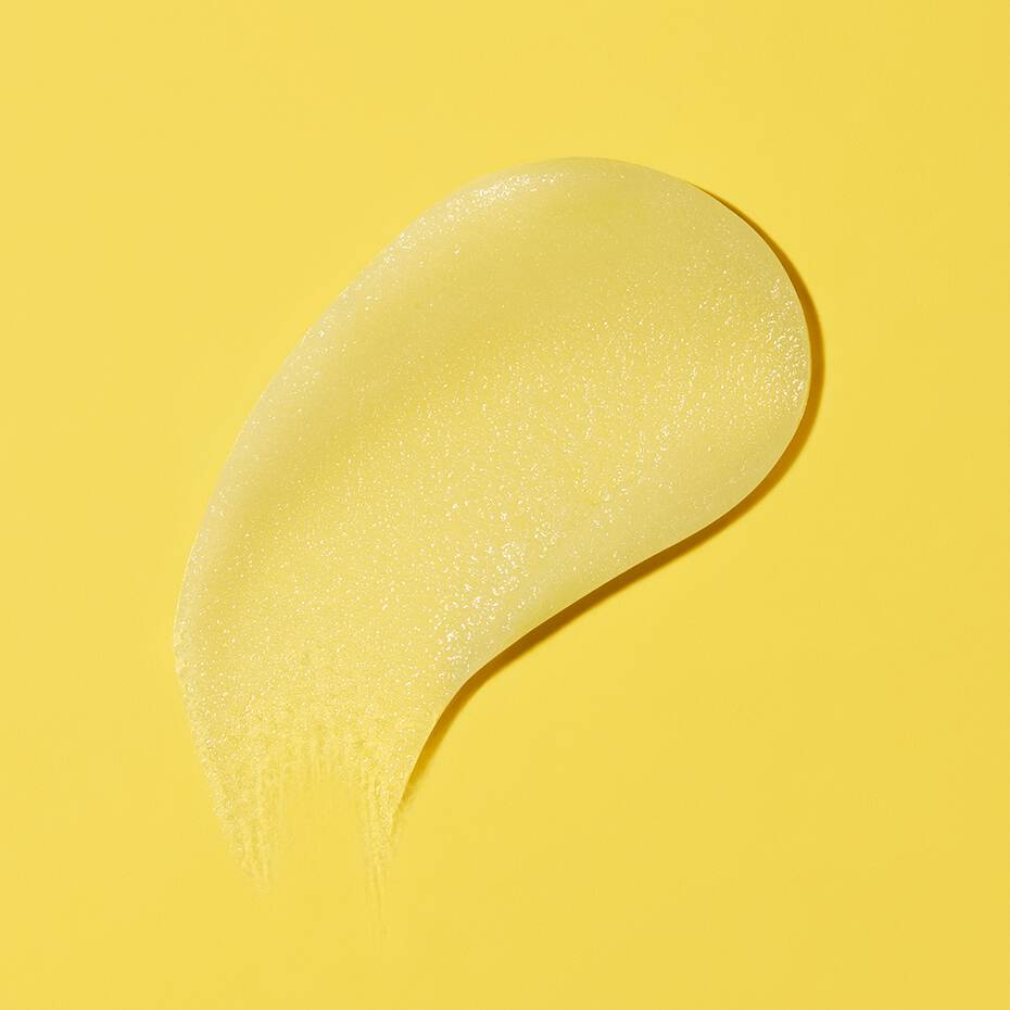 A dollop of gel substance smeared on a yellow background.