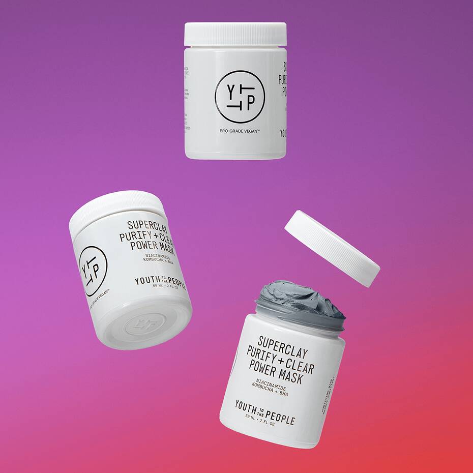 Three skincare products by youth to the people displayed against a gradient background with one lid floating above a jar of what appears to be a clay mask.